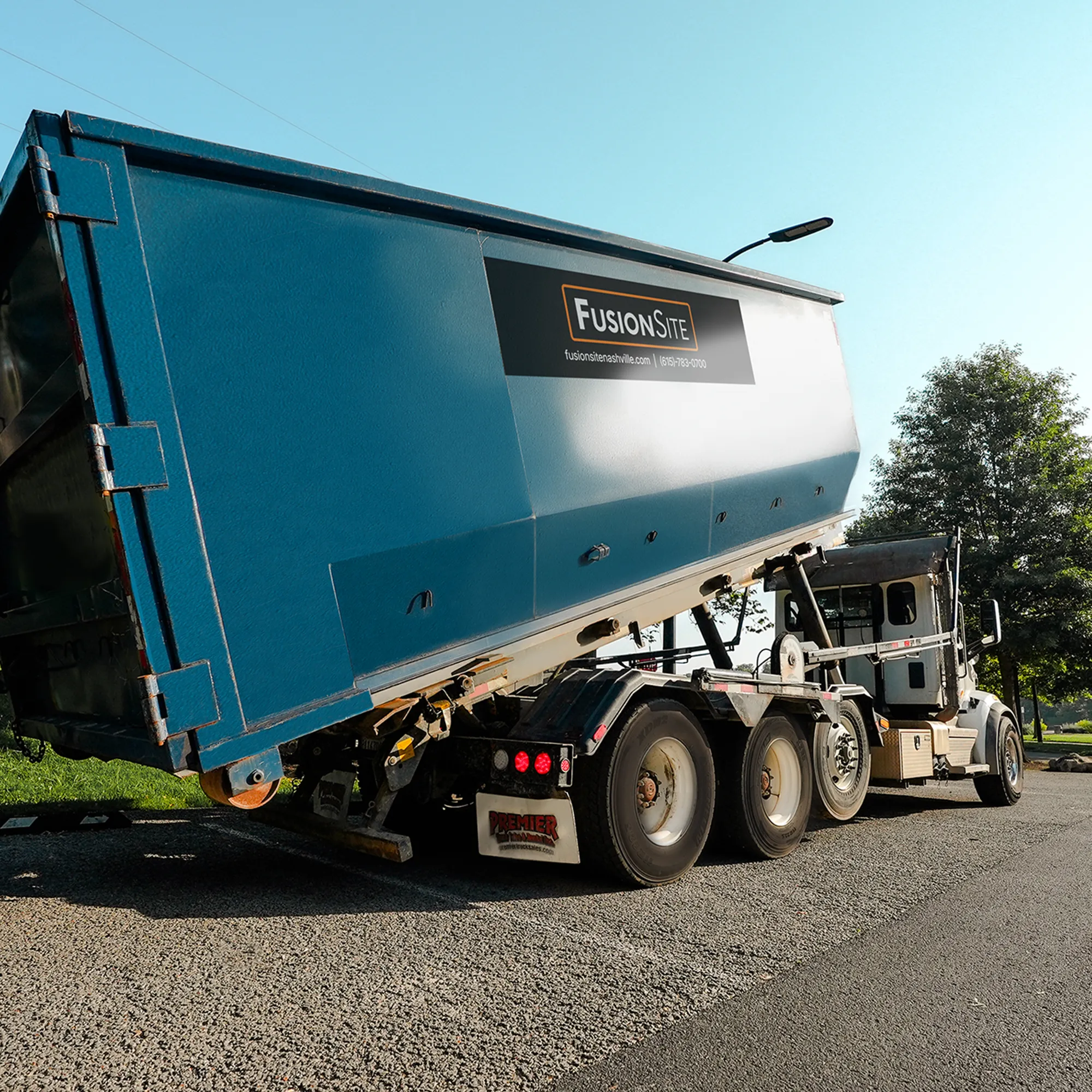 roll off dumpster rental truck dropping off a at a construction site